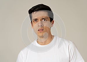 Portrait of a young man looking scared and shocked. Human expressions and emotions