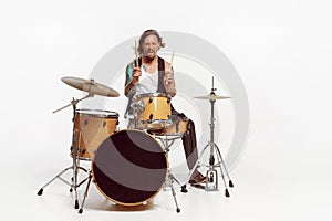 Portrait of young man playing drums, performing isolated over white studio background. Tattoo art on body