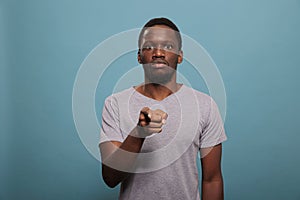 Portrait of young man pointing index finger at camera