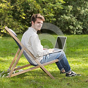 Portrait of young man on profile sitting with laptop computer