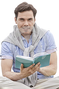 Portrait of young man reading book against sky