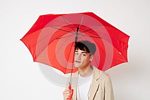 portrait of a young man red umbrella a man in a light jacket isolated background unaltered