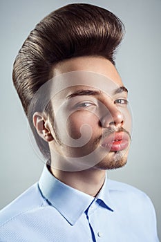Portrait of young man with retro classic pompadour hairstyle. photo