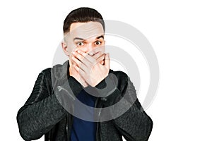 Portrait of young man scared and closes mouth hands. Isolated on white background