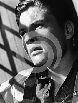 Portrait of young man with shadow of bars