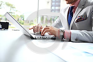 Portrait of young man sitting at his desk in the office