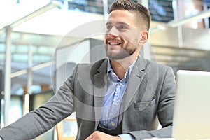 Portrait of young man sitting at his desk in the office.