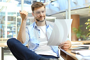 Portrait of young man sitting at his desk in the office