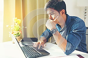 Portrait of young man sitting at his desk in the office