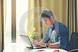 Portrait of young man sitting at his desk in the office