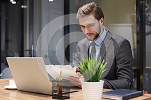 Portrait of young man sitting at his desk in the office