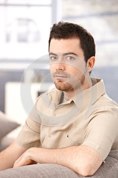 Portrait of young man sitting in living room