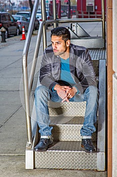 Portrait of young Man sitting outdoors, relaxing, thinking