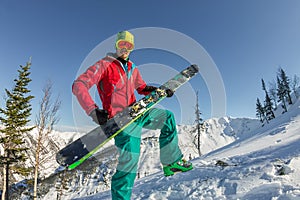 Portrait young man ski goggles holding ski in the mountains