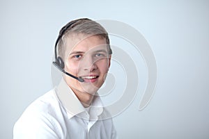 Portrait of young man smiling sitting on gray background. Portrait of young man