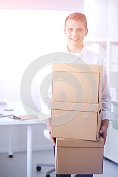 Portrait of young man smiling sitting on gray background. Portrait of young man