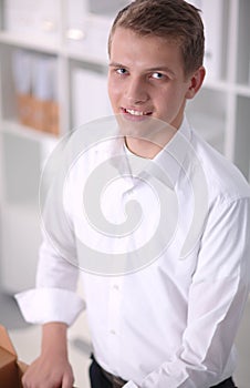 Portrait of young man smiling sitting on gray background. Portrait of young man