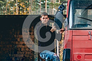 Portrait of young man stand on side on truck cabin