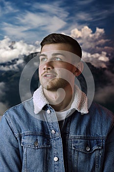 Portrait of a young man standing against mountains