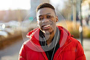Portrait of a young man standing in a city street, smiling