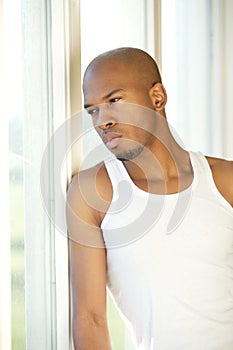 Portrait of a young man standing by window
