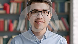 Portrait young man student smiling bookshelf library university