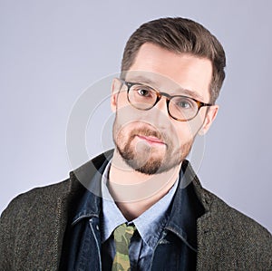 Portrait of a young man in stylish, modern clothes. Glasses and