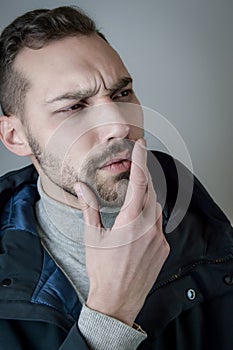 Portrait of a young man touching his chin in a moment of doubt or reflection