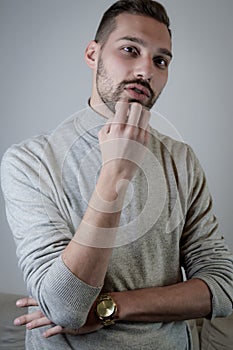 Portrait of a young man touching his chin in a moment of doubt or reflection