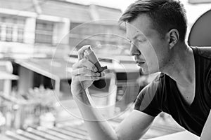 Portrait of young man using asthma inhaler at home