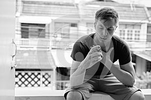 Portrait of young man using asthma inhaler at home