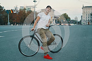 Portrait of young man walking with thoughtfully classic bicycle