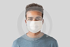 Portrait of a young man wearing protective face mask. Masked men portrait isolated on gray background