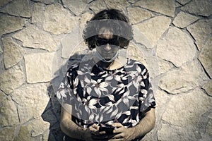 Portrait of young man wearing sunglasses and lowered medical protective mask for disobey State security regulations during covid