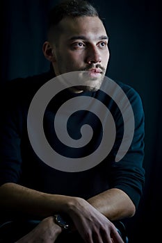 Portrait of a young man who, with his gaze elsewhere, seems lost in his thoughts