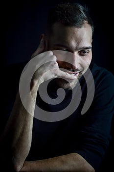 Portrait of a young man who pretends to telephone with his hand while smiling