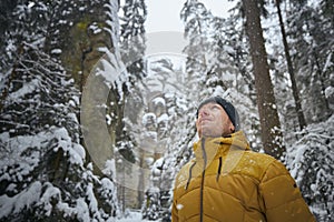 Portrait of young man in winter nature during snowing