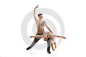 Portrait of young man and woman, figure skating athletes performing isolated over white studio background