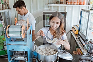 Portrait young man and woman selling meatball