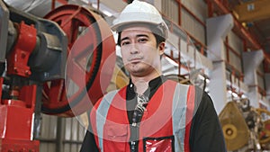 Portrait of young man worker in safety uniform of large modern factory crossing arms on chest