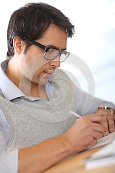 Portrait of young man writing notes