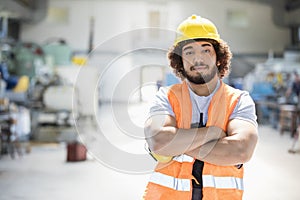 Portrait of young manual worker standing arms crossed in metal industry