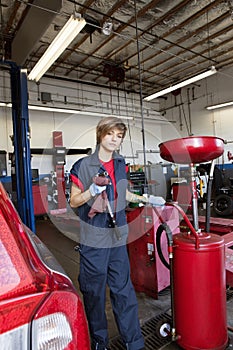 Portrait of a young mechanic standing by welding equipment
