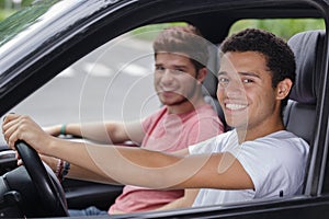 portrait young men in front seats car