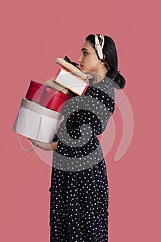 Portrait of young middle-eastern woman holding stack of gift boxes. Receiving lot of presents. Romantic surprises