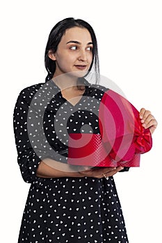 Portrait of young middle-eastern woman surprised with gift box. Female unpacking romantic present box from her lover