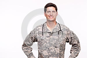 Portrait of a young military doctor posing against white background.