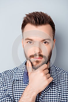 Portrait of young minded man touching his chin