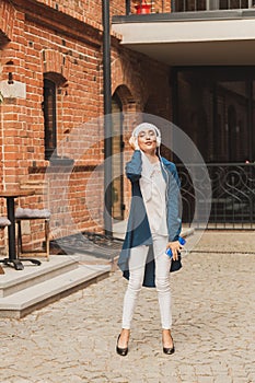 Portrait of young modern arabian woman holding mobile phone and listening the music to headphone.