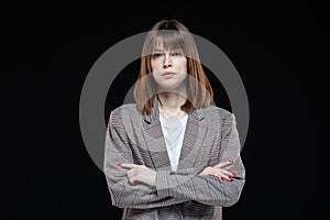 Portrait of a young modern business woman in a jacket on a black isolated background.